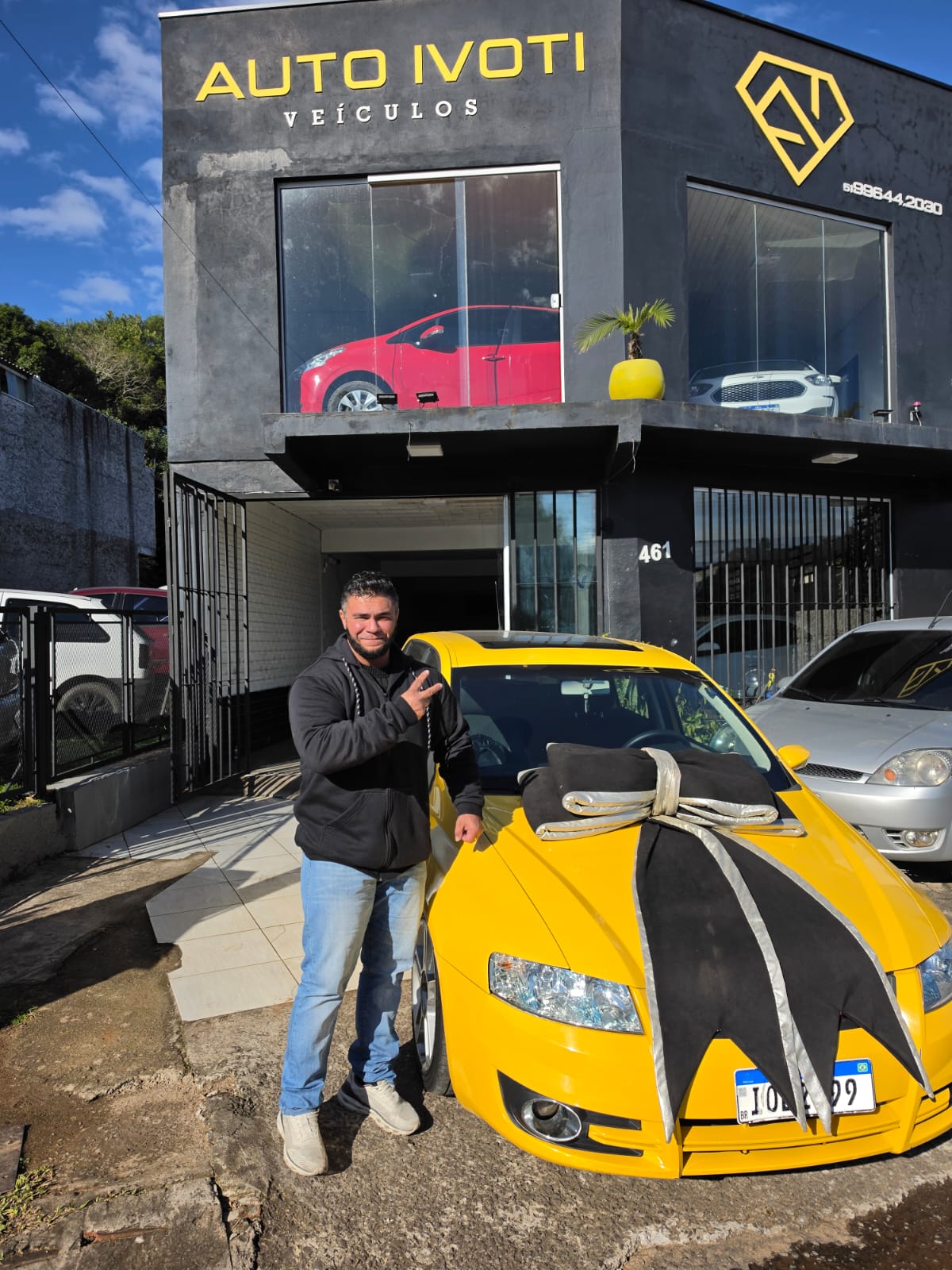 Cliente comemorando a entrega do carro amarelo